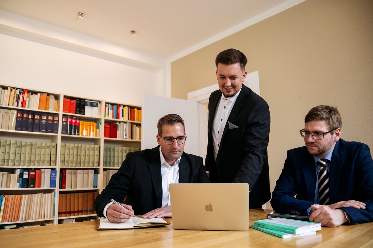 Die drei Gründer von Legal Mind bei der gemeinsamen Arbeit am Kanzleitisch